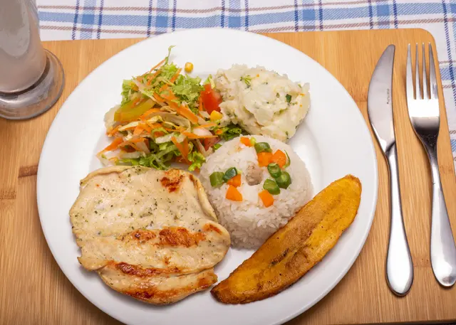 Almuerzo con filete de pollo, arroz y acompañamientos